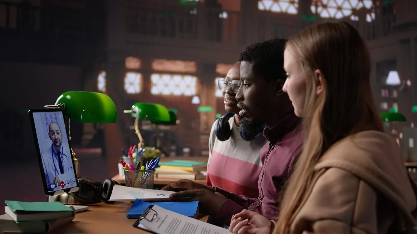 Разнообразная группа студентов общается по видеосвязи с врачом.