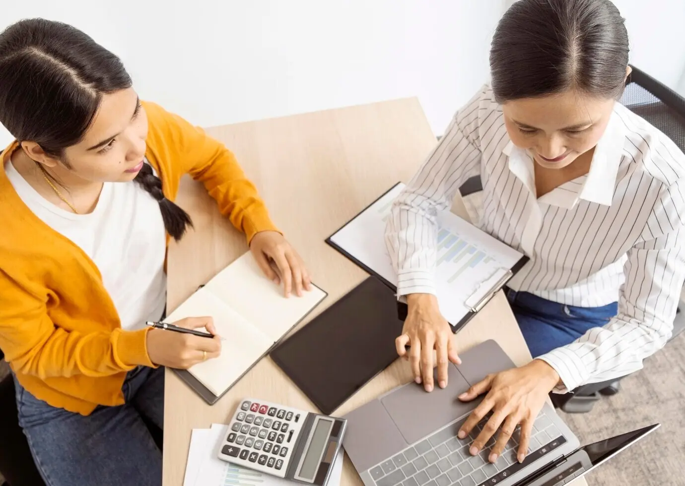 Высокий ракурс: азиатские женщины размышляют над новыми идеями для рабочего проекта.